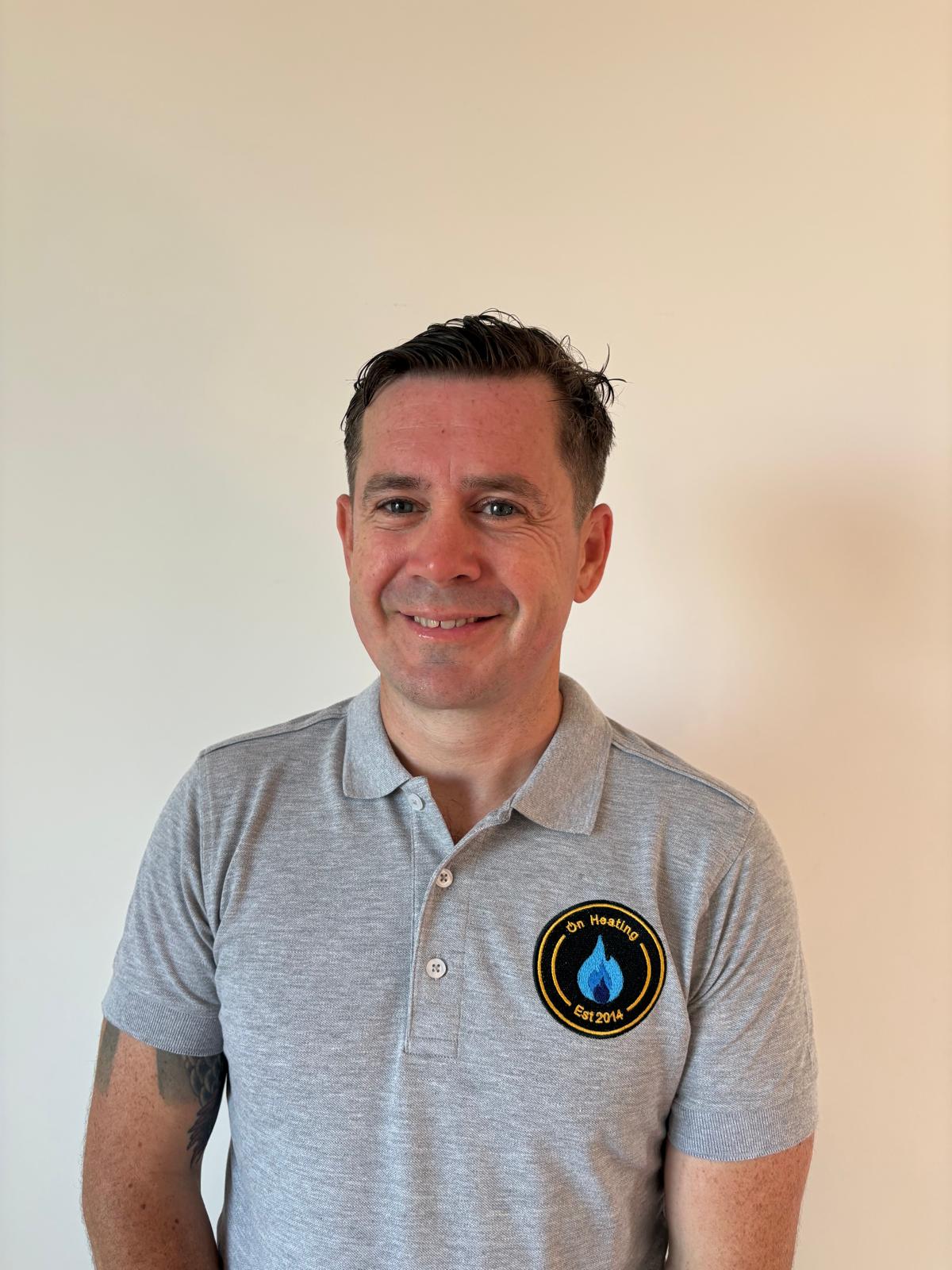 Lee Pierson, owner of On Heating, wearing an On Heating branded polo shirt.